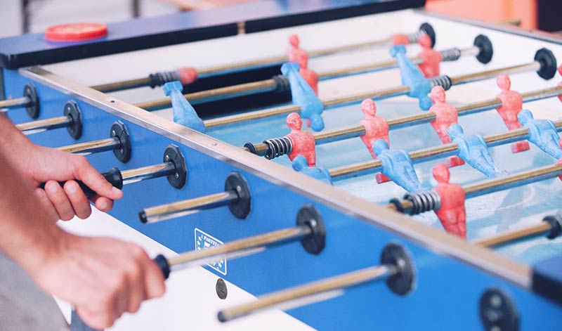 Playing table football in games room