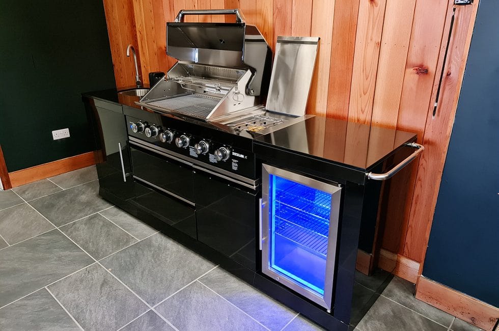Fridge, sink and storage alongside the grill