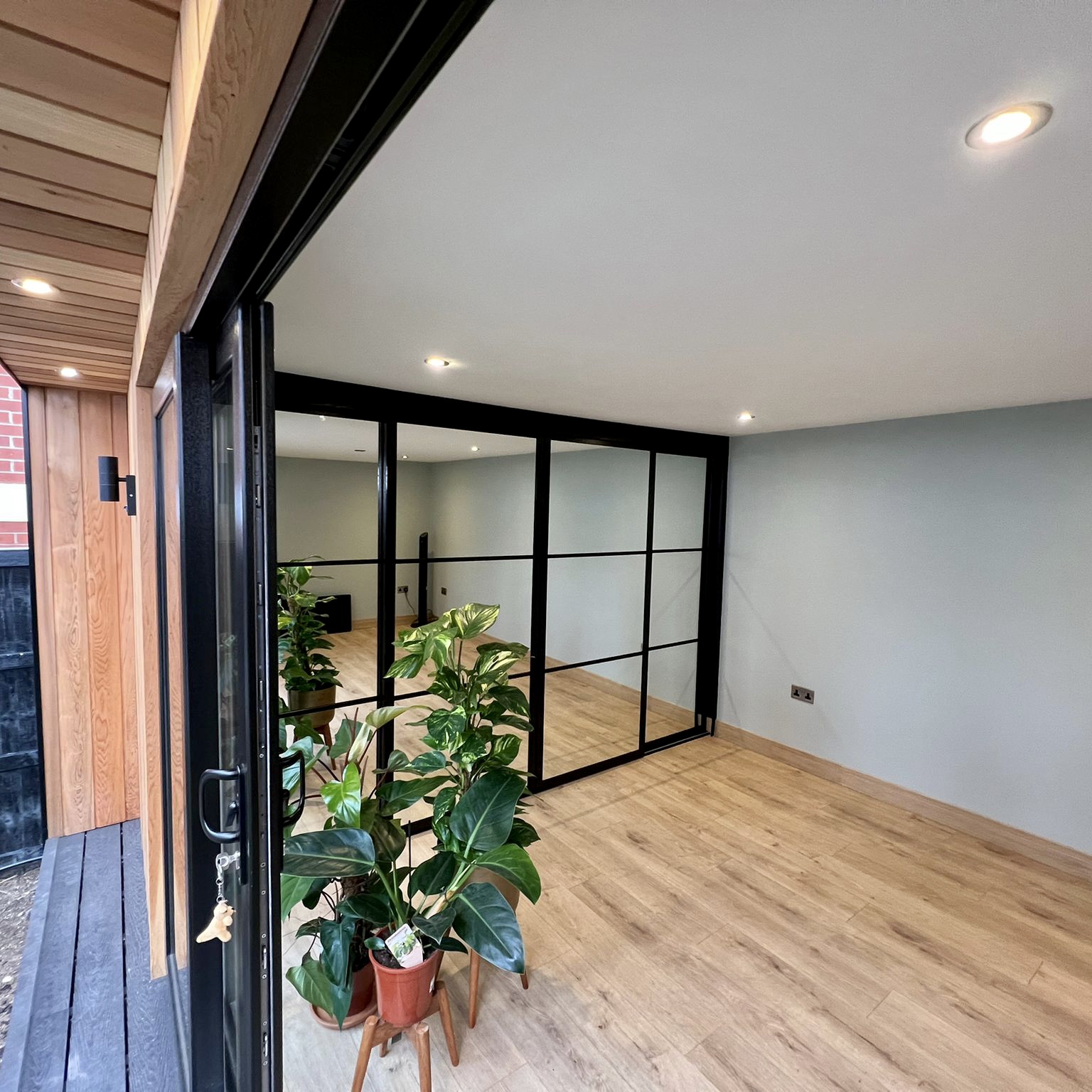 Garden studio interior in Surrey showing workspace layout and natural light through glazed doors
