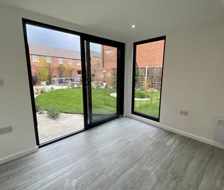 Composite garden room in black Cedral with full height windows