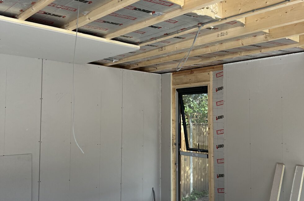 Garden room under construction with upgraded insulation to meet building regulations, featuring a thicker layer for improved U-values.