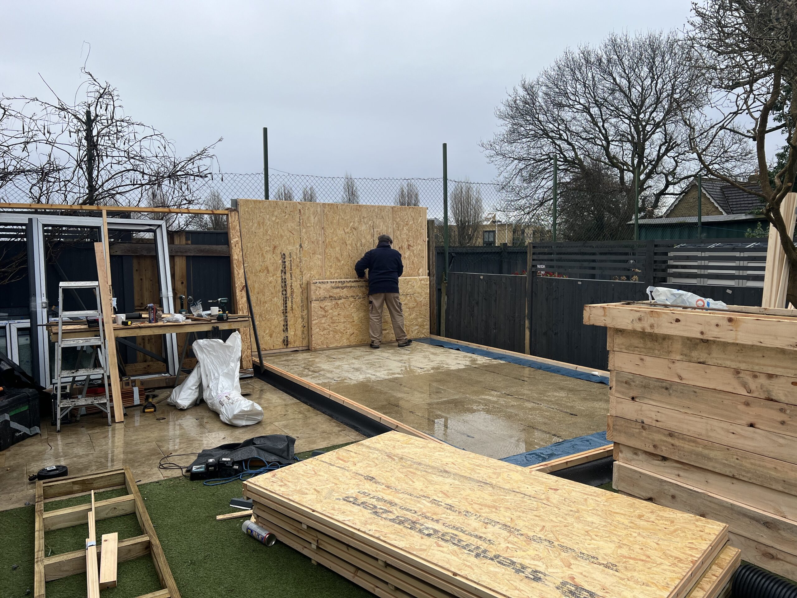 Steel floor frame installed and first wall going into position during garden room build