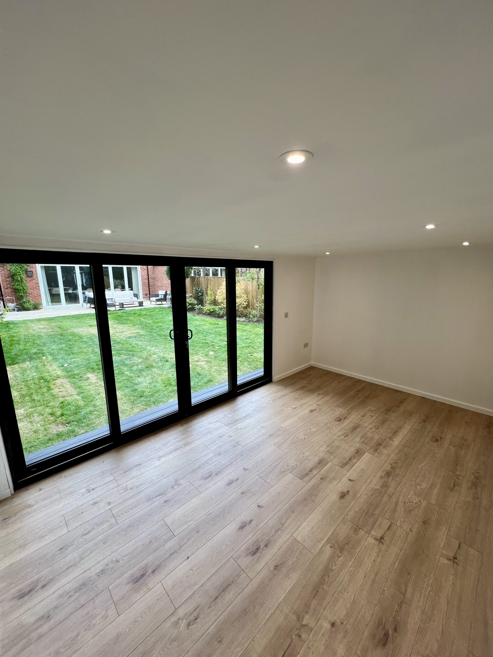 Interior of bespoke garden room with laminate flooring and 4-pane sliding doors