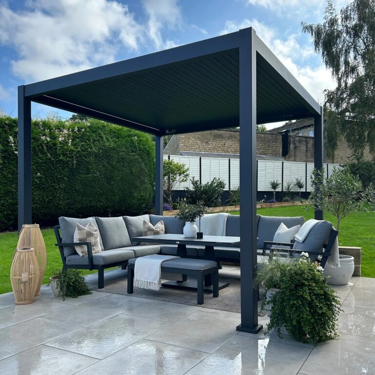 Grey aluminium pergola with a louvred roof over a patio seating area with a corner sofa and dining table