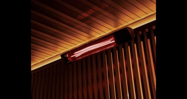 Infrared heater glowing red, mounted under a louvred pergola roof